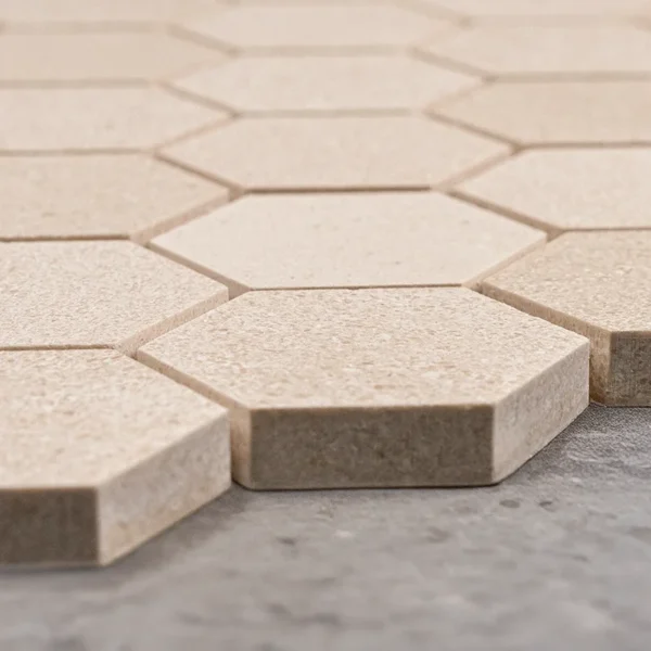 Close-up side view of honed limestone honeycomb mosaic tile in 2-inch hexagon format with beige color and smooth matte surface.