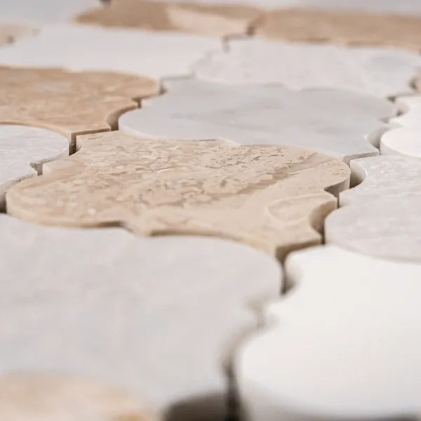 Textured surface and natural color variation of Arabesque polished marble mosaic tile in beige, gray and white tones