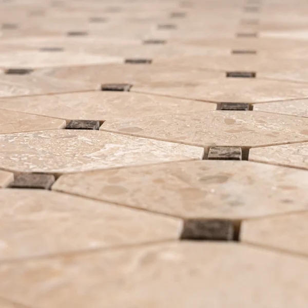 Detailed surface view of Royal Beige and Emperador marble mosaic tile in clipped diamond pattern with polished finish