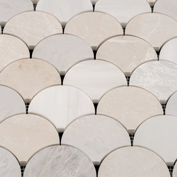 Top-down close-up of Dolomite, Iceberg with icy veining, and Vanilla marble fish scale mosaic tiles showcasing the polished surface and natural stone variations in soft white and beige tones