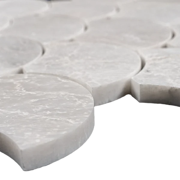 Close-up view of polished Iceberg marble fish scale mosaic tile showing smooth surface, icy veining, and curved edge details for a luxurious wall application