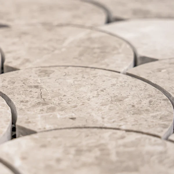 Close-up of polished fish scale mosaic tiles made from Silver Diamond marble, highlighting natural tones, curved edges, and reflective finish