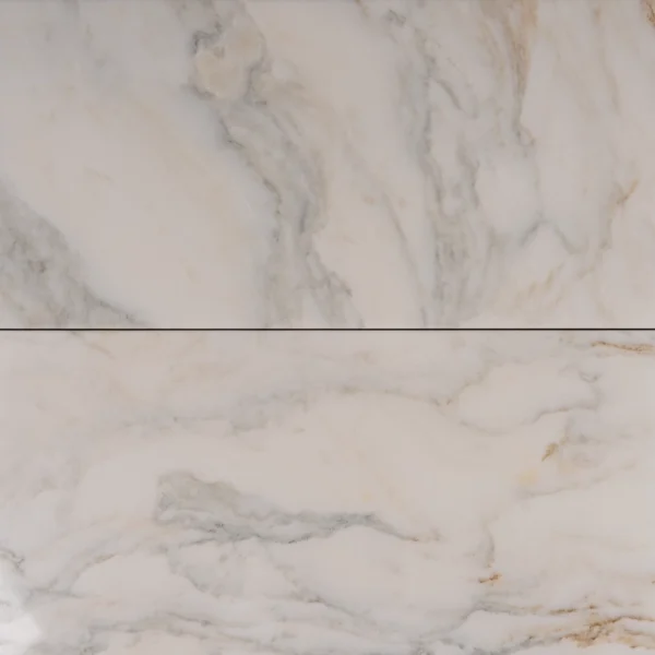 Close-up view of two Calacatta 12x24 polished marble tiles with rich golden and grey veining, showcasing beveled edges and smooth finish.