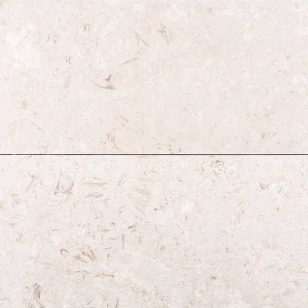 Close-up of two adjacent Myra Beige tiles, highlighting their straight edges and consistent natural veining.