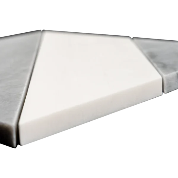 A close-up angled view of a white and gray marble mosaic tile sheet featuring a polished diamond pattern. The varying heights of the tiles reveal the craftsmanship and attention to detail, while the combination of gray veining and smooth white marble showcases the luxurious quality of the stone.