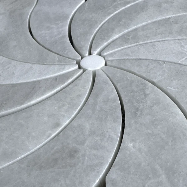 Macro view of central starburst design created by interwoven leaf-shaped marble tiles