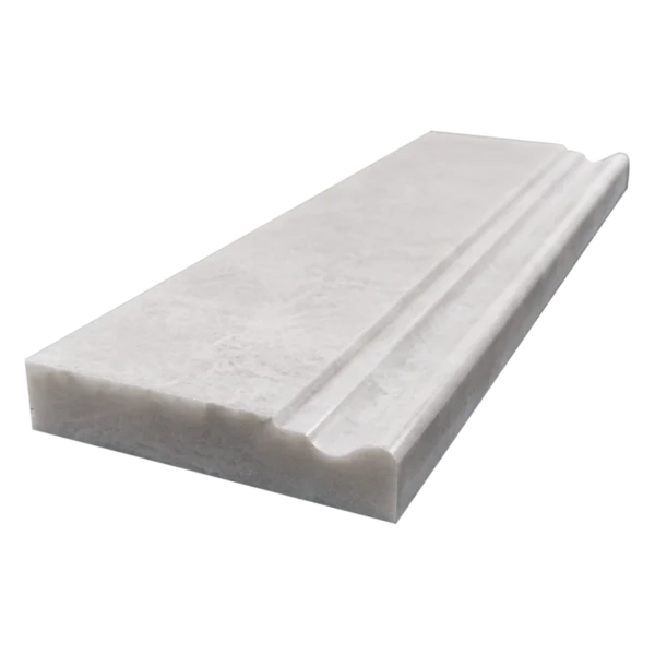 Angled perspective of white Iceberg marble baseboard trim highlighting the honed structure and decorative profile.