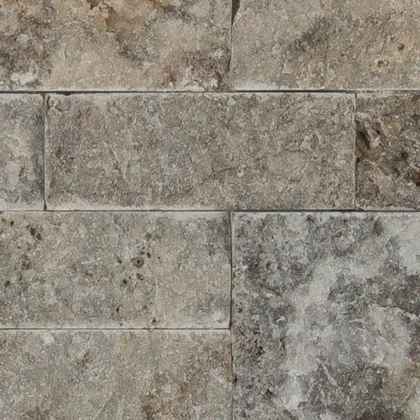 Close-up of Triverra 6x24 3D ledgestone panel featuring natural travertine in mixed beige and gray tones