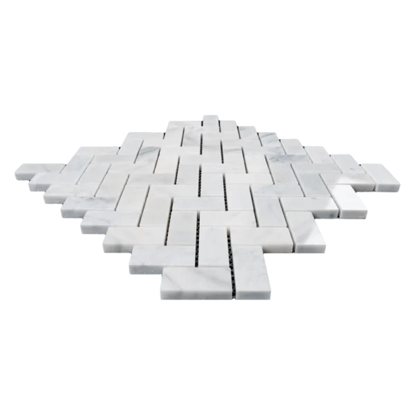Low-angle side profile of Carrara 1"x2" polished herringbone mosaic sheet highlighting tile thickness and edges.