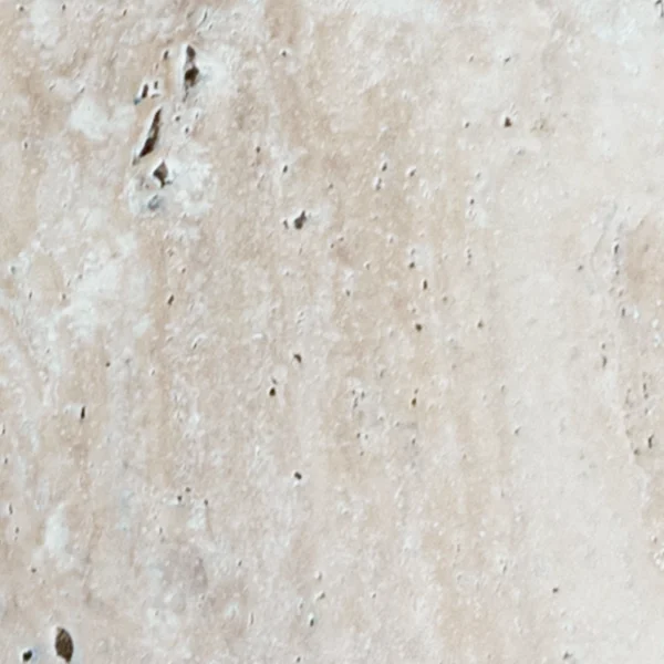 Close-up view of Desert Bloom 6x12 tumbled travertine paver showing its warm beige hues, weathered finish, and organic surface details for rustic outdoor designs.