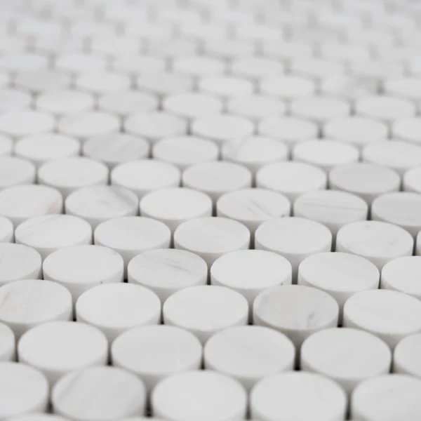 Close-up of Dolomite penny honed marble mosaic tile showing smooth circular white marble pieces with soft veining.