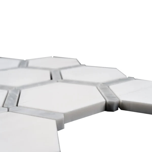 Low-angle close-up showing the Dolomite marble surface and Carrara detailing between the polished hexagon tiles.