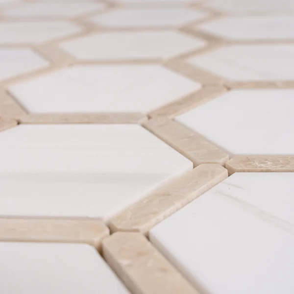Close-up angled view of Dolomite with Royal Beige Touch polished marble mosaic, highlighting the glossy surface and hexagonal layout.