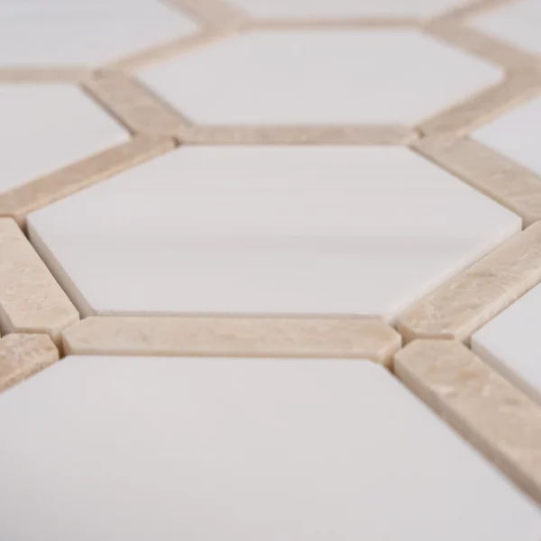 Macro detail of Dolomite with Royal Beige Touch polished marble hexagon tiles, showcasing contrast between white dolomite and beige marble borders.