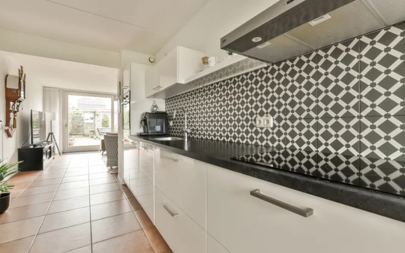 Black and white patterned mosaic tile backsplash in modern kitchen