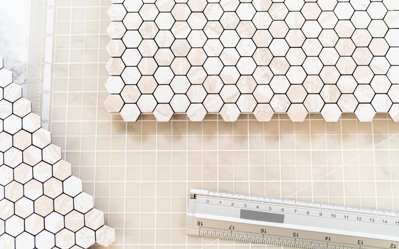 Hexagon mosaic tile sheets with measuring tools showing layout and sizing details for accurate installation