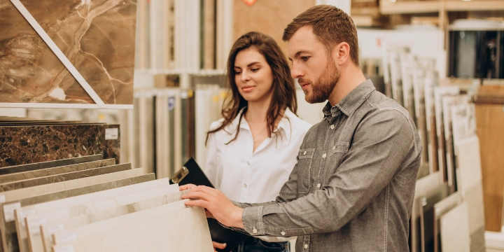 Customers choosing marble tile samples in a natural stone showroom