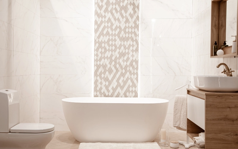 modern bathroom with beige mosaic tile accent wall, freestanding bathtub and natural marble wall tiles