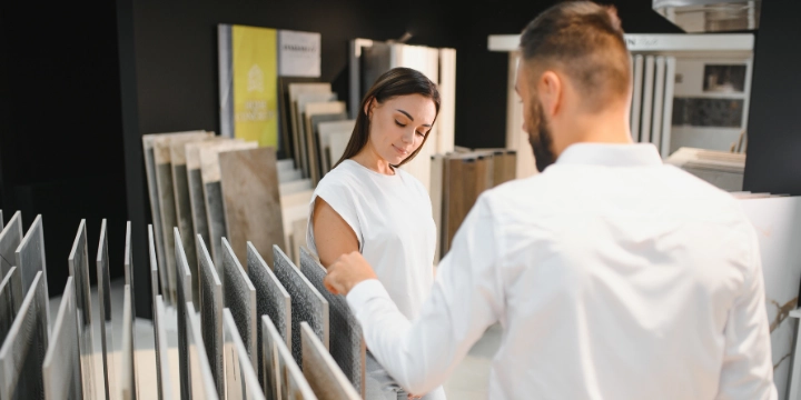alt="Customer selecting natural stone mosaic tiles in a showroom in Delray Beach, Florida"