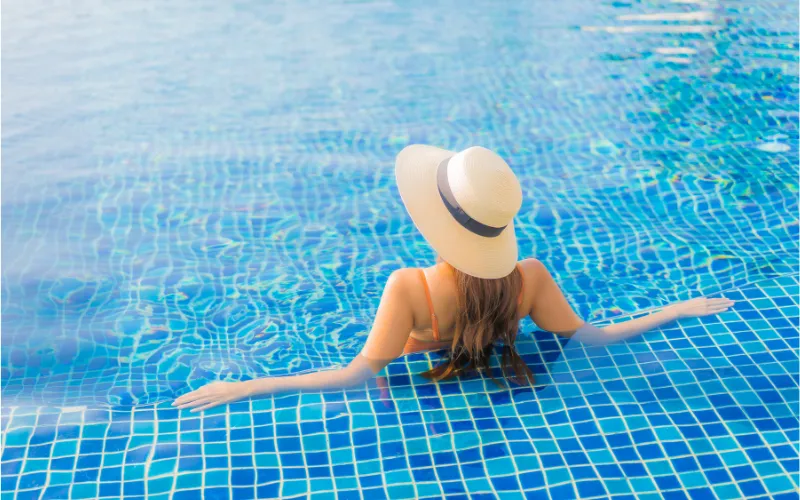 Relaxing in a luxury swimming pool finished with premium blue glass mosaic tiles and clear water.