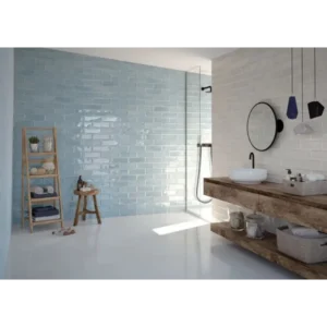 Bathroom shower area decorated with light blue Happy Floors Titan Aqua 4x12 glossy ceramic subway wall tiles.