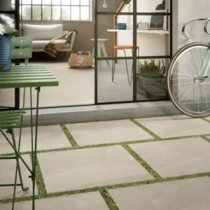 X-Rock B 24x48 2CM Grip Sanded Porcelain Pavers installed on an outdoor patio with lounge chairs and garden landscaping.