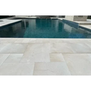 Crema Bella 16x24 leather finish pavers on a modern outdoor pool deck with natural stone flooring