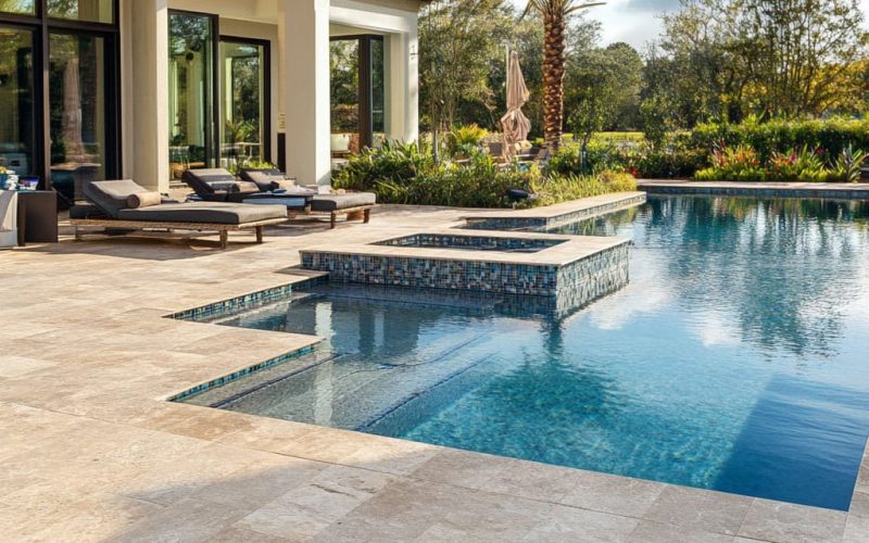 Travertine pavers surrounding a pool, showcasing slip-resistant and durable natural stone in a luxurious outdoor setting